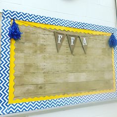 a wooden sign hanging on the side of a building with blue and white chevrons