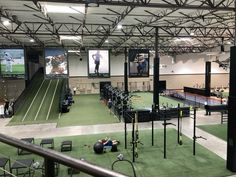 an indoor tennis court with equipment and people