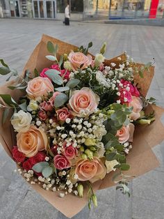 a bouquet of flowers sitting on top of a sidewalk