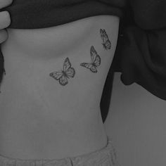 a woman's stomach with three butterflies on it