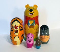 five different toy animals are lined up in the shape of a bear, winnie the pooh and tigger