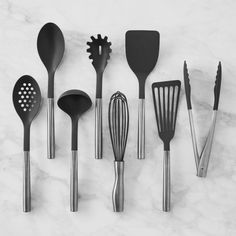 kitchen utensils lined up on a marble surface