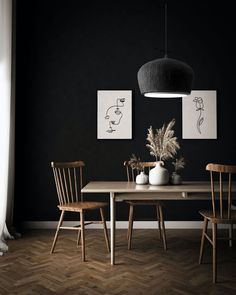 a dining room table with two vases on it and three chairs in front of the table