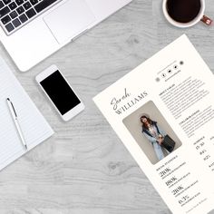 a professional resume is displayed next to a laptop, phone and cup of coffee on a desk