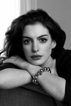 a black and white photo of a woman sitting on a couch with her arms crossed