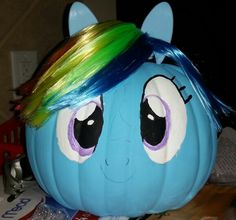 a blue pumpkin with rainbow hair on it's face and eyes painted to look like a pony