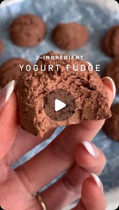 a hand holding a chocolate cookie with the words yogurt fudge on it