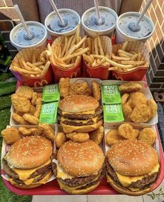 a table topped with lots of hamburgers and fries