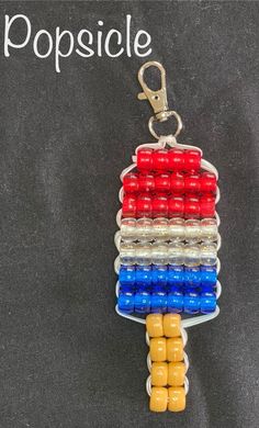 a keychain made out of legos on top of a chalkboard with the words popsicle written in white