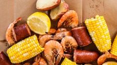 corn on the cob, shrimp, and potatoes with lemon wedges in a brown paper bag