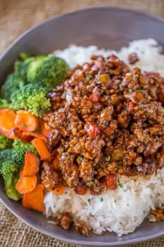 a bowl filled with rice, meat and broccoli on top of a table