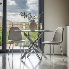 a glass table with two chairs next to it