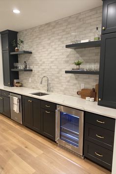 an empty kitchen with black cabinets and white counter tops is seen in this image from the front view