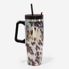 an animal print travel mug with the word ame on it and a straw sticking out