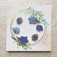 a card with blue flowers and leaves on it