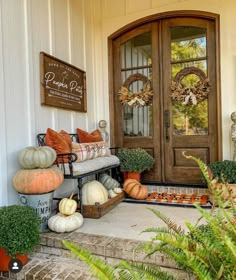 a front porch decorated with pumpkins and gourds