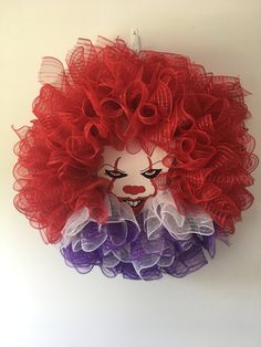 a clown face made out of red, white and purple tulle ruffles