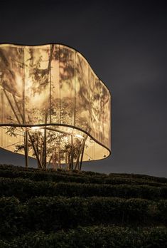 a large lamp that is sitting on top of a grass covered hill in the dark