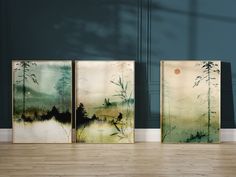 three paintings on the wall in an empty room with wood flooring and blue walls