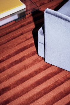 a couch sitting on top of a wooden floor next to a book shelf and coffee table