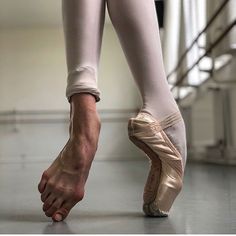 a ballerina's feet and ballet shoes on the floor