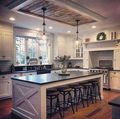 a large kitchen with an island in the middle and lots of stools around it