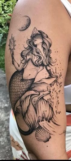 a woman with a mermaid tattoo on her arm