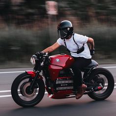 a man riding on the back of a red motorcycle