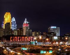 the city skyline is lit up at night with bright lights in the buildings and traffic