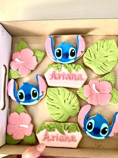 a box filled with decorated cookies in the shape of lillies