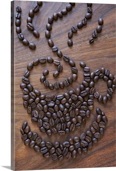 coffee beans arranged in the shape of a man's face on a wooden surface