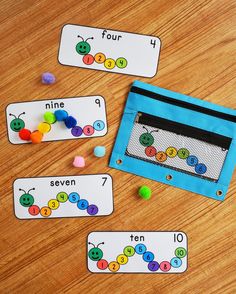 three cards with numbers on them sitting next to a blue bag filled with buttons and beads