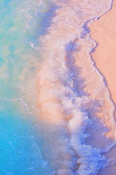 an ocean beach with waves coming in to the shore and blue water on top of it