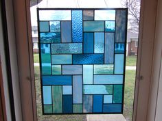 a stained glass window sitting on the side of a door in front of a house