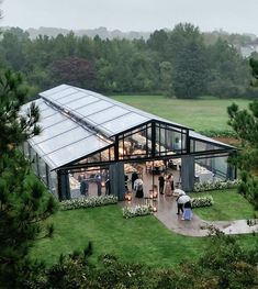 an aerial view of people standing in front of a glass house