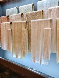 towels hanging on the wall in front of a window with blue walls and windowsills