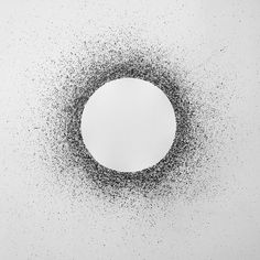 an abstract black and white photo with dots in the shape of a circle on a wall