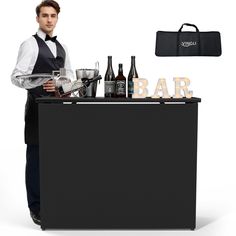 a man standing behind a bar holding a tray