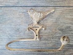 a bird is perched on the handle of a towel bar that has been cast iron