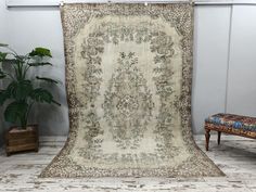 an antique rug is on display in a room with a bench and potted plant