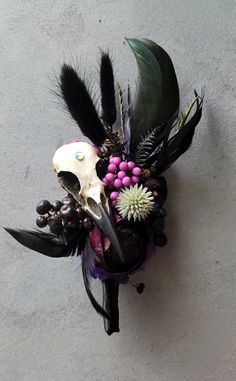 a skull with feathers and flowers in it