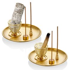 two gold trays with toothbrushes and some sort of cup on top of them