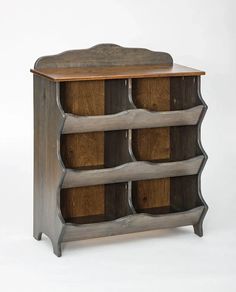 a wooden shelf with several compartments on the top and bottom, sitting against a white background