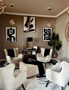 a living room filled with white chairs and art on the wall above them is an area rug covered in black and white geometrics