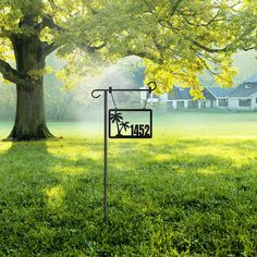 a sign that is in the grass near a tree