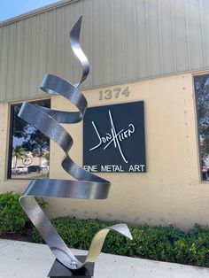 a metal sculpture in front of a building with a sign that says,'fine metal art '