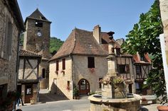 an old stone building with a fountain in the middle