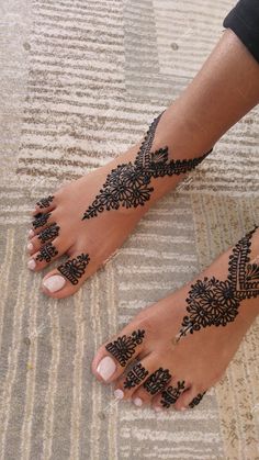 a woman's feet with henna tattoos on them