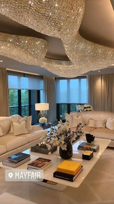 a living room filled with furniture and a chandelier hanging from the ceiling above