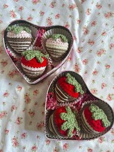 two heart shaped tins filled with crocheted strawberries